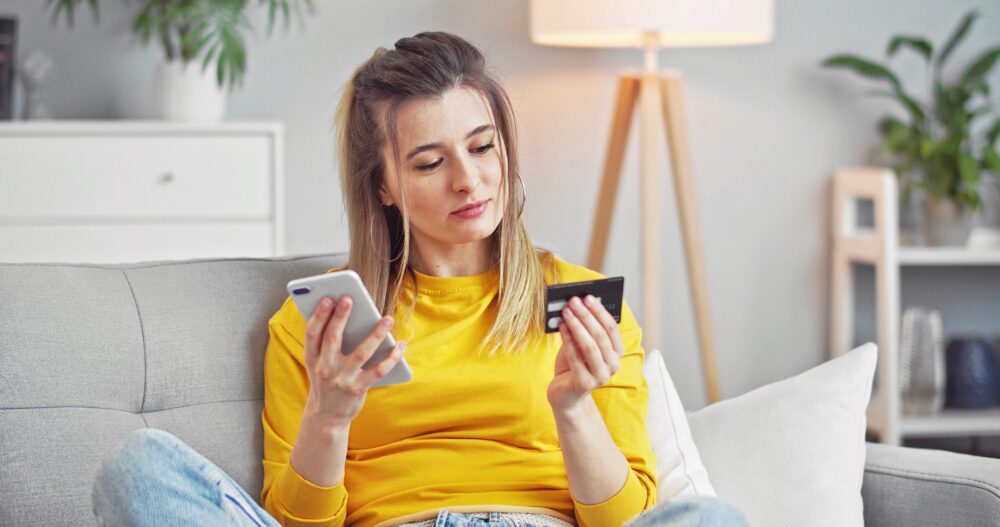 young woman using smartphone and credit card shopp HTRQSKY 1