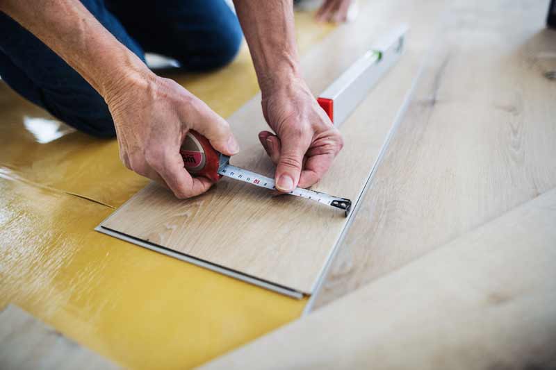 a midsection of senior man laying vinyl flooring 2021 08 26 12 09 25 utc