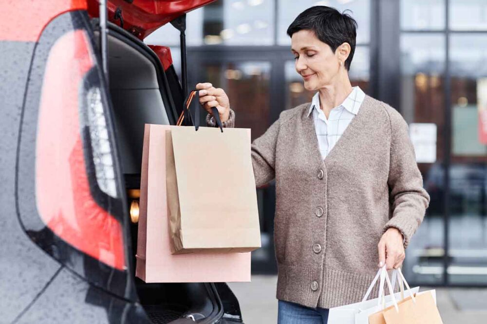 smiling woman putting shopping bags on car trunk o 2023 11 27 05 07 29 utc