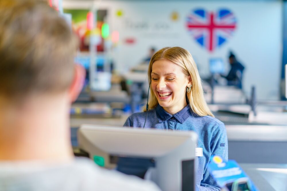 Lidl employee woman smiling at a till