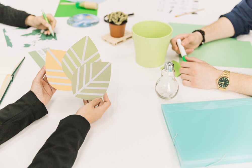 a group of people holding paper leaves