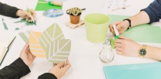 a group of people holding paper leaves