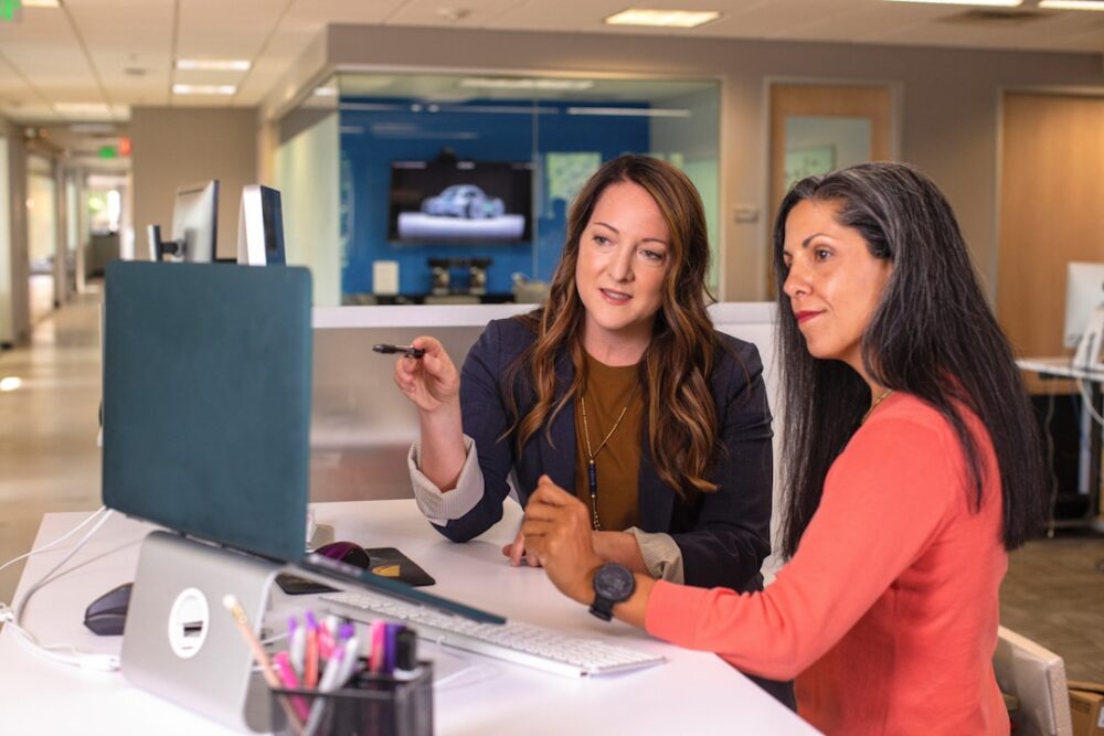 Two professionals discussing the key components of a successful account plan, one presenting information and the other listening attentively.