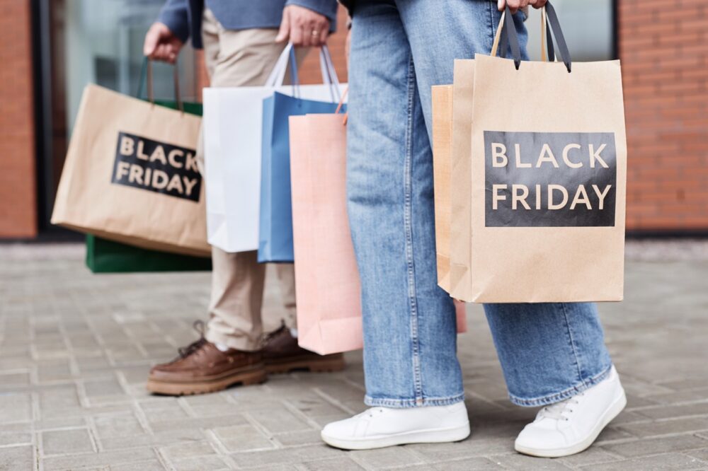 of couple holding black friday shopping bags walki 2023 11 27 04 51 33 utc Large