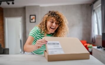 excited young woman opening a cardboard delivery b 2026 04 30 21 33 40 utc Large