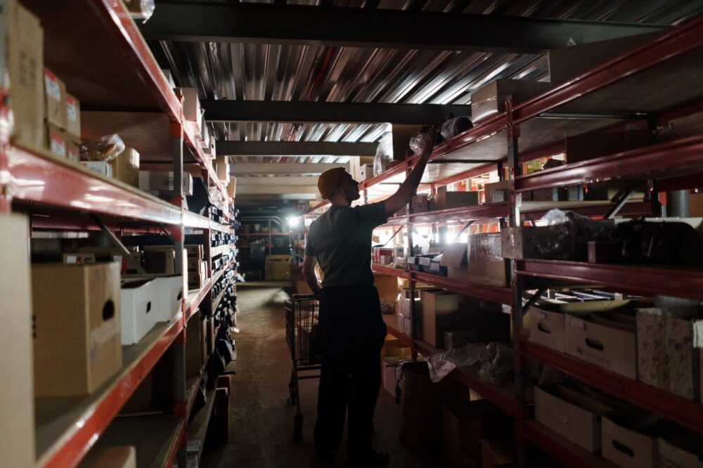 A person arranging inventory on shelves in a warehouse.
