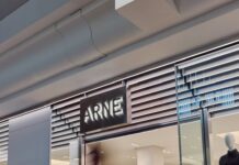 The ARNE pop-up at Bluewater, with an illuminated ARNE sign above the entrance, a mannequin in the window and shoppers inside