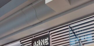 The ARNE pop-up at Bluewater, with an illuminated ARNE sign above the entrance, a mannequin in the window and shoppers inside