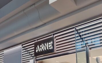 The ARNE pop-up at Bluewater, with an illuminated ARNE sign above the entrance, a mannequin in the window and shoppers inside