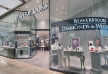 Beaverbrooks store frontage in a shopping centre, with illuminated signage, a Diamonds & Weddings window of jewellery displays and a TAG Heuer store next door