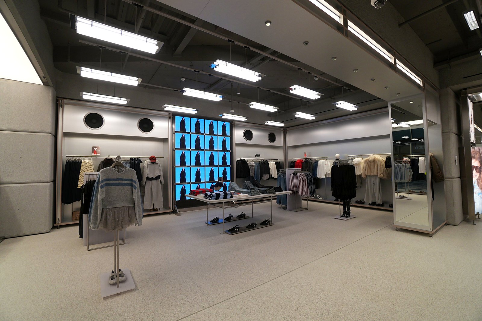 Womenswear area inside Bershka at Westgate Oxford with a video wall, clothing rails and a central display table of denim and shoes