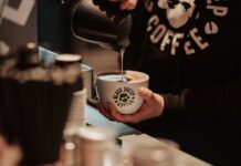 Black Sheep Coffee to Open on Gordon Street in Glasgow Barista pouring steamed milk into a Black Sheep Coffee branded cup at the counter