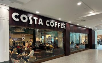 Costa Coffee frontage inside The Liberty shopping centre, with customers seated behind full-height glazing and a Freshly Baked Pastries sign