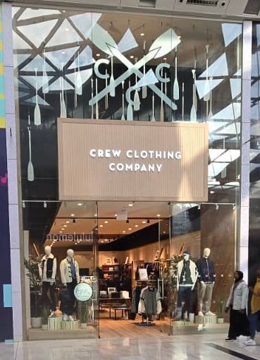 Crew Clothing Company shopfront at Westfield London, with crossed-oar graphics on the glazing and menswear on mannequins in the window