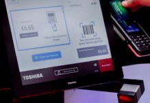 Seamless Payment Journeys in Focus Ahead of EuroCIS 2027 Self-checkout with a Toshiba screen showing a card payment, a red-lit barcode scanner and a shopper holding a card at the payment terminal