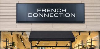 French Connection outlet shopfront at Dalton Park, with black fascia signage, a black awning over the entrance and mannequins in jackets and jeans in the windows