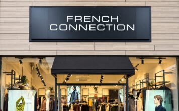 French Connection outlet shopfront at Dalton Park, with black fascia signage, a black awning over the entrance and mannequins in jackets and jeans in the windows