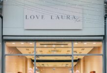Group of people standing outside the Love Laura store at The Boulevard, beneath the Love Laura Xo sign, with pink balloons inside the windows