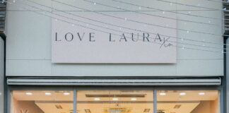 Group of people standing outside the Love Laura store at The Boulevard, beneath the Love Laura Xo sign, with pink balloons inside the windows