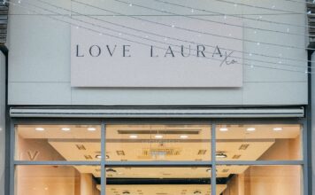 Group of people standing outside the Love Laura store at The Boulevard, beneath the Love Laura Xo sign, with pink balloons inside the windows