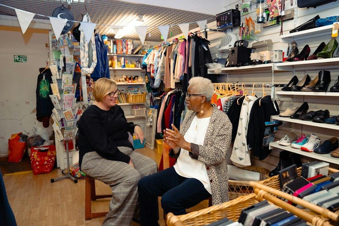 Two women talking in a cluttered shop