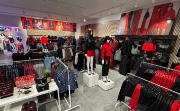 New Look Reopens Refurbished Cribbs Causeway Store Inside the refurbished New Look store at Cribbs Causeway, with mannequins, rails of red and black partywear, an accessories table and campaign imagery above slatted wall panels