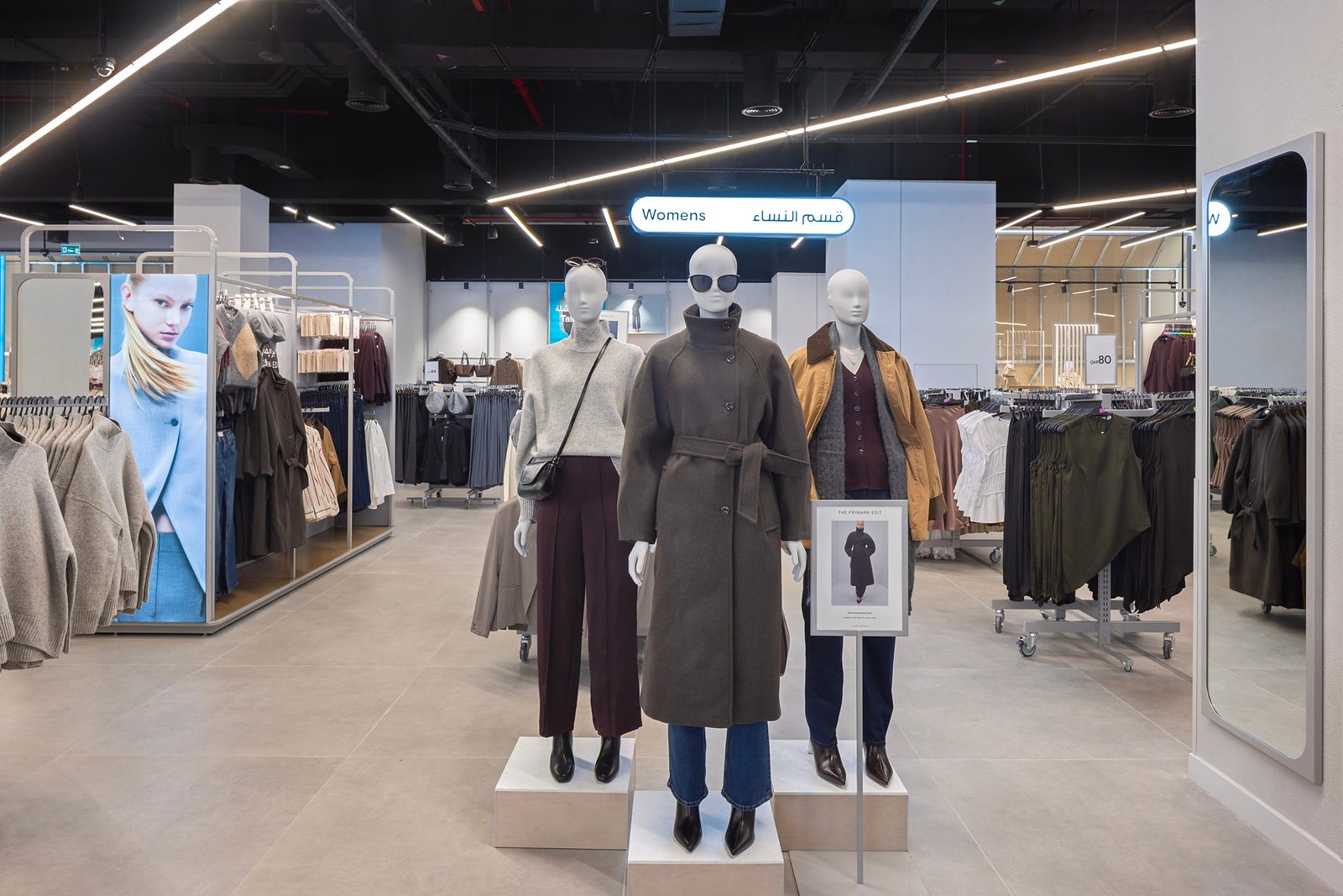 Womenswear area at Primark Doha Festival City, with mannequins in autumn coats and knitwear beneath a Womens sign in English and Arabic