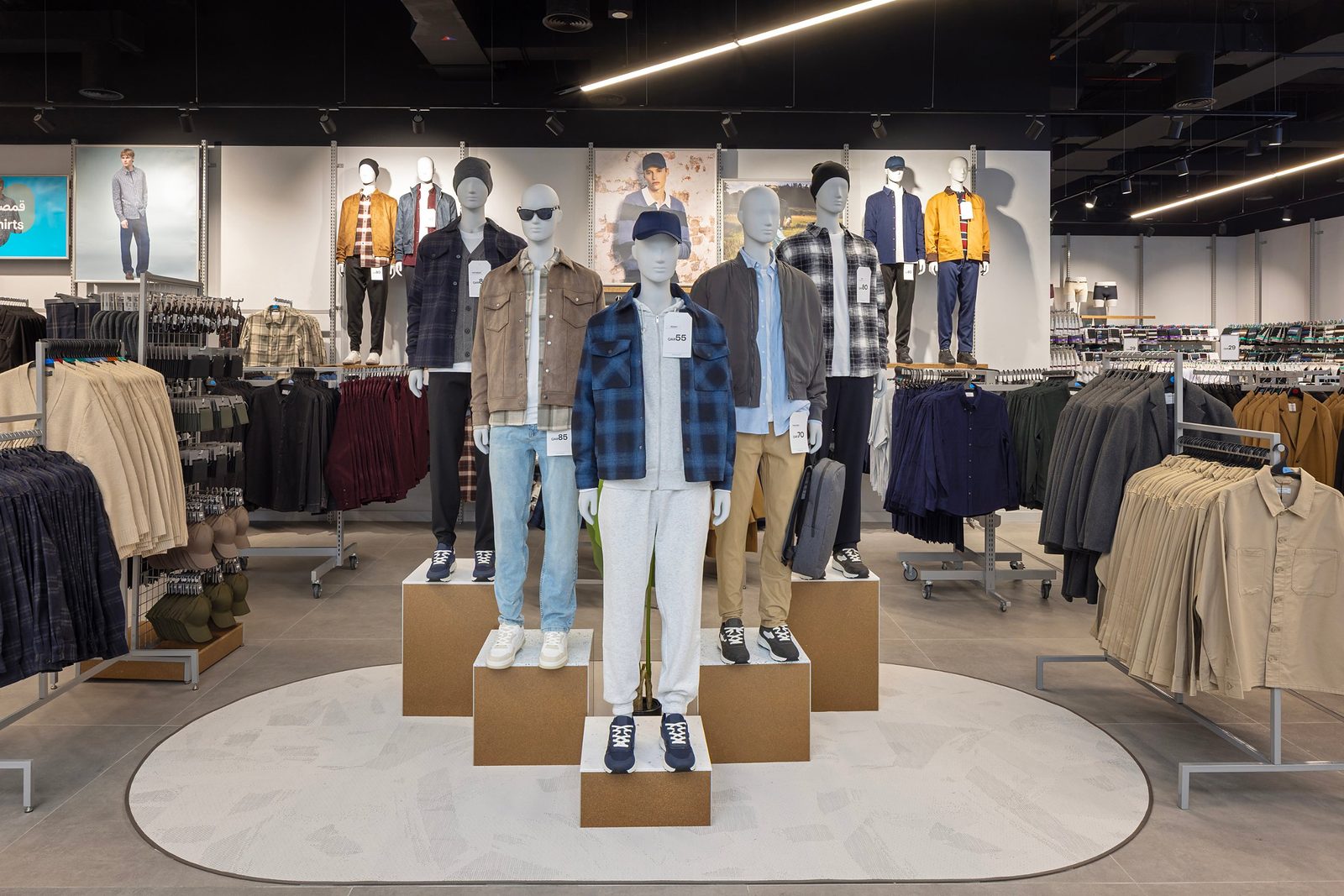 Menswear display with mannequins in jackets and shirts on staggered plinths