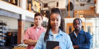 Retail People Index Finds 25 to 44-Year-Olds Struggling Most Three retail workers standing in a clothing shop, the woman in front holding a tablet