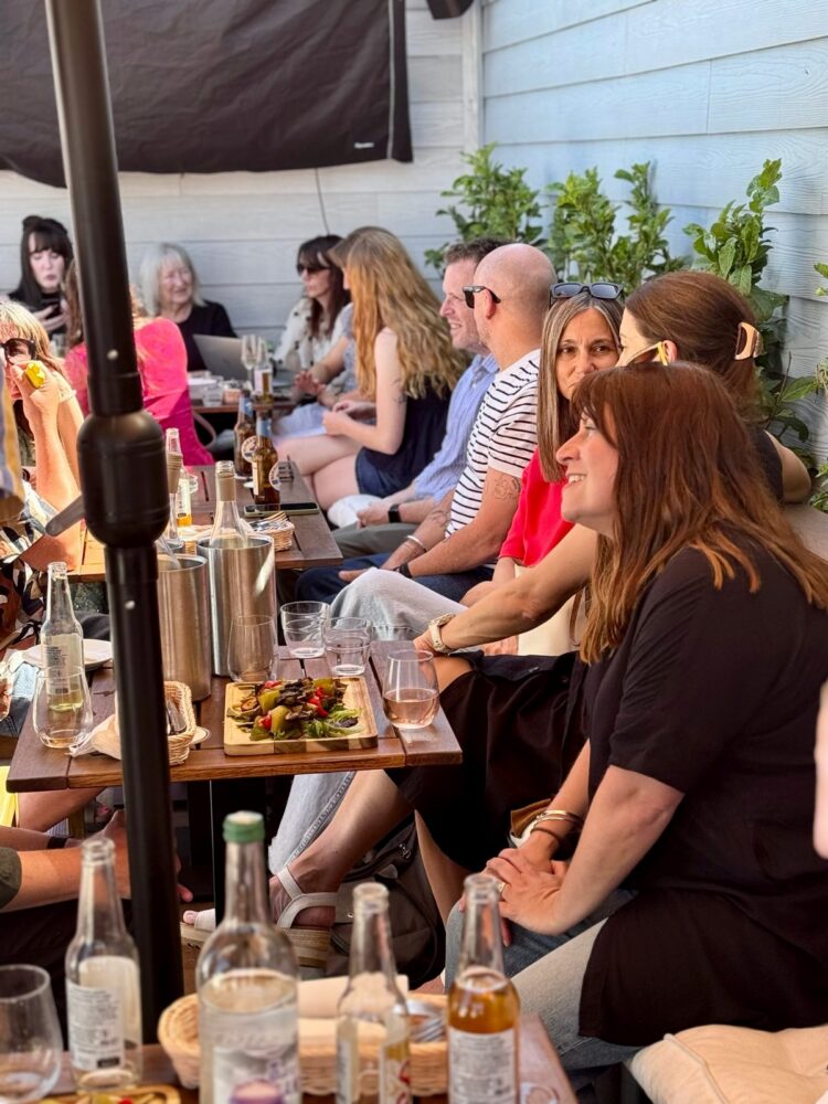 Guests seated at tables with drinks and food at the SDEA Summer Social, July 2026