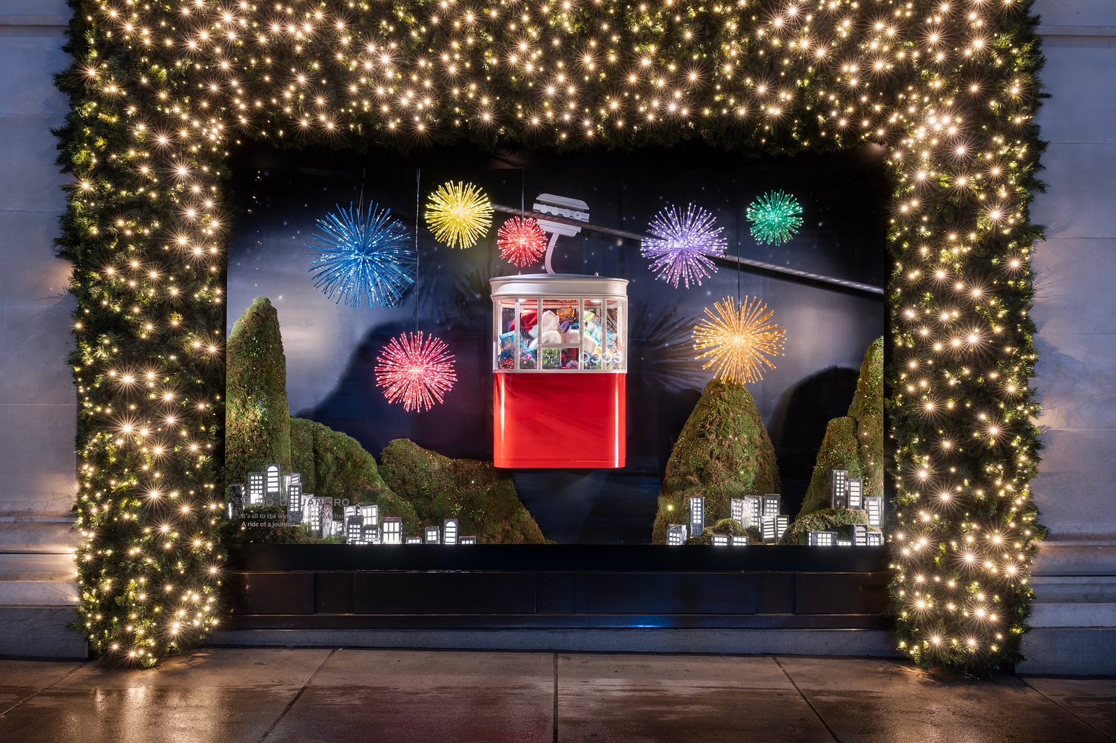 Selfridges' Rio de Janeiro Christmas window, with a red cable car above green hills and fireworks