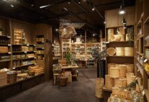 Søstrene Grene store interior with rattan baskets, ceramics and glassware on wooden shelves and display tables