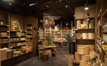 Søstrene Grene store interior with rattan baskets, ceramics and glassware on wooden shelves and display tables