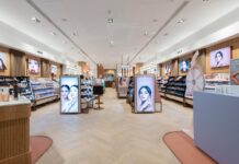 Interior of a Space NK store, with make-up and skincare fixtures, illuminated brand displays and herringbone timber flooring