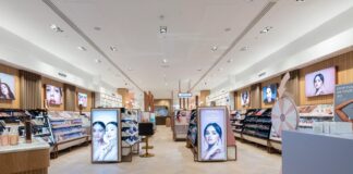 Interior of a Space NK store, with make-up and skincare fixtures, illuminated brand displays and herringbone timber flooring