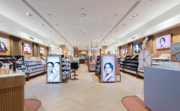 Interior of a Space NK store, with make-up and skincare fixtures, illuminated brand displays and herringbone timber flooring