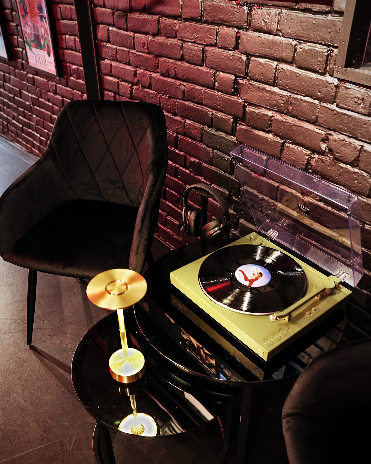 A Victrola turntable with headphones on a side table beside an armchair at UMusic Shop Camden