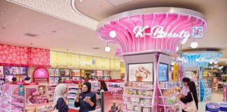 Pink illuminated K-Beauty zone at Watsons Plus, with a staff member helping a customer at a make-up display nearby