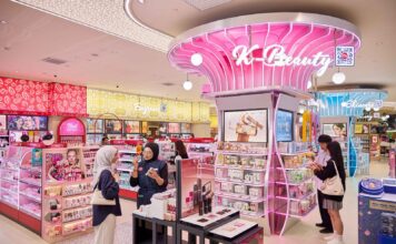 Pink illuminated K-Beauty zone at Watsons Plus, with a staff member helping a customer at a make-up display nearby