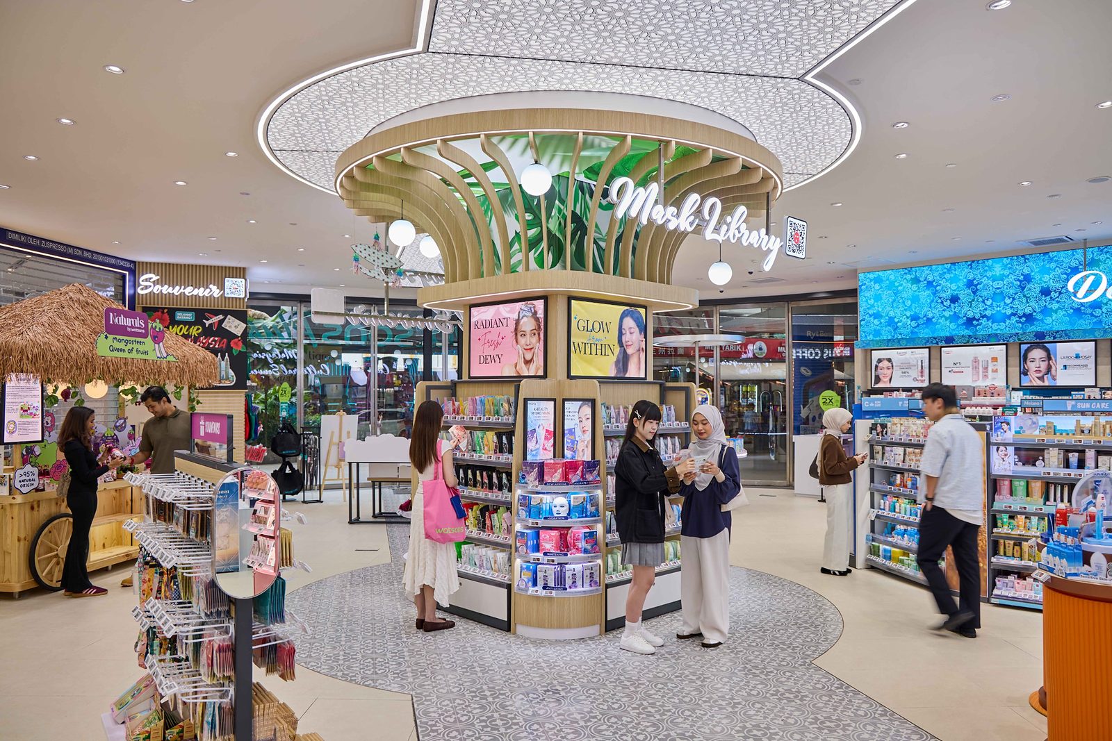 Mask Library fixture beneath a timber canopy at Watsons Plus, with shoppers browsing facial masks and a souvenir area to the left